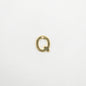 Gold letter 'Q' charm on a white background