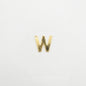 Gold letter 'W' charm on a white background