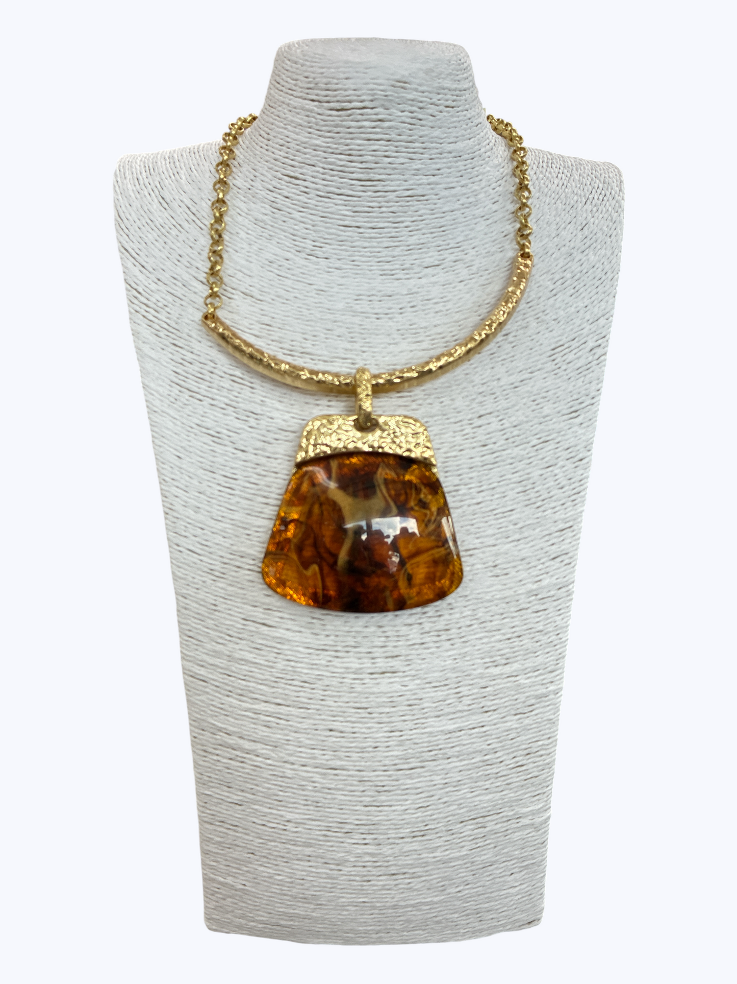 Modern boutique necklace featuring textured metallic collar chain with oversized faux amber resin geometric pendant.