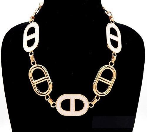 Gold and white oval-link necklace on a black mannequin