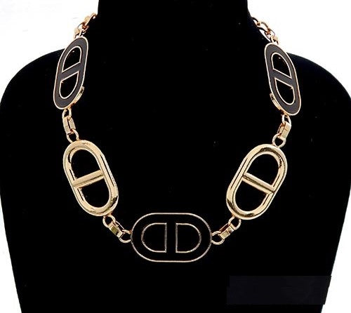 Gold chain necklace on a black mannequin