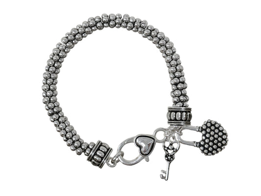Vintage-inspired multi-strand bead bracelet with key charm details and rustic silver-tone finish.