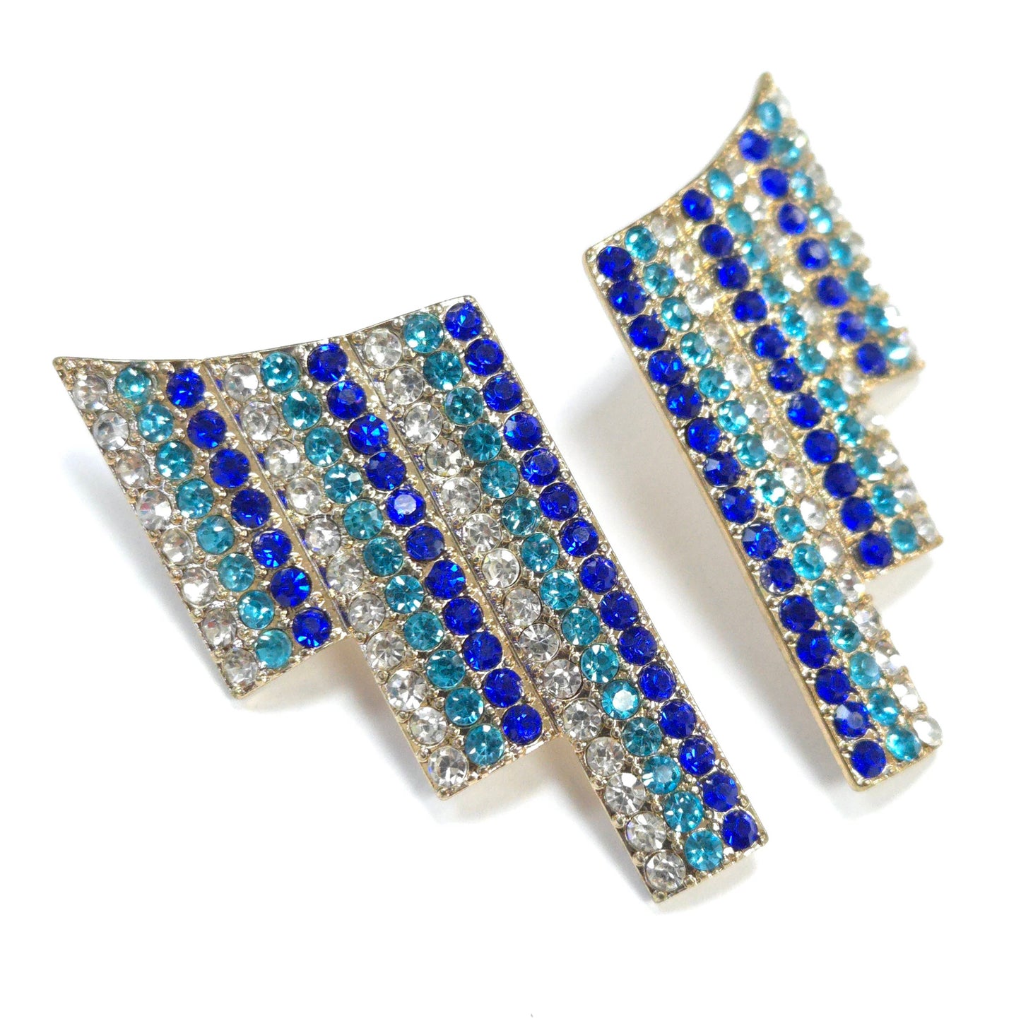Pair of arrow-shaped earrings with blue and clear gemstones on a white background