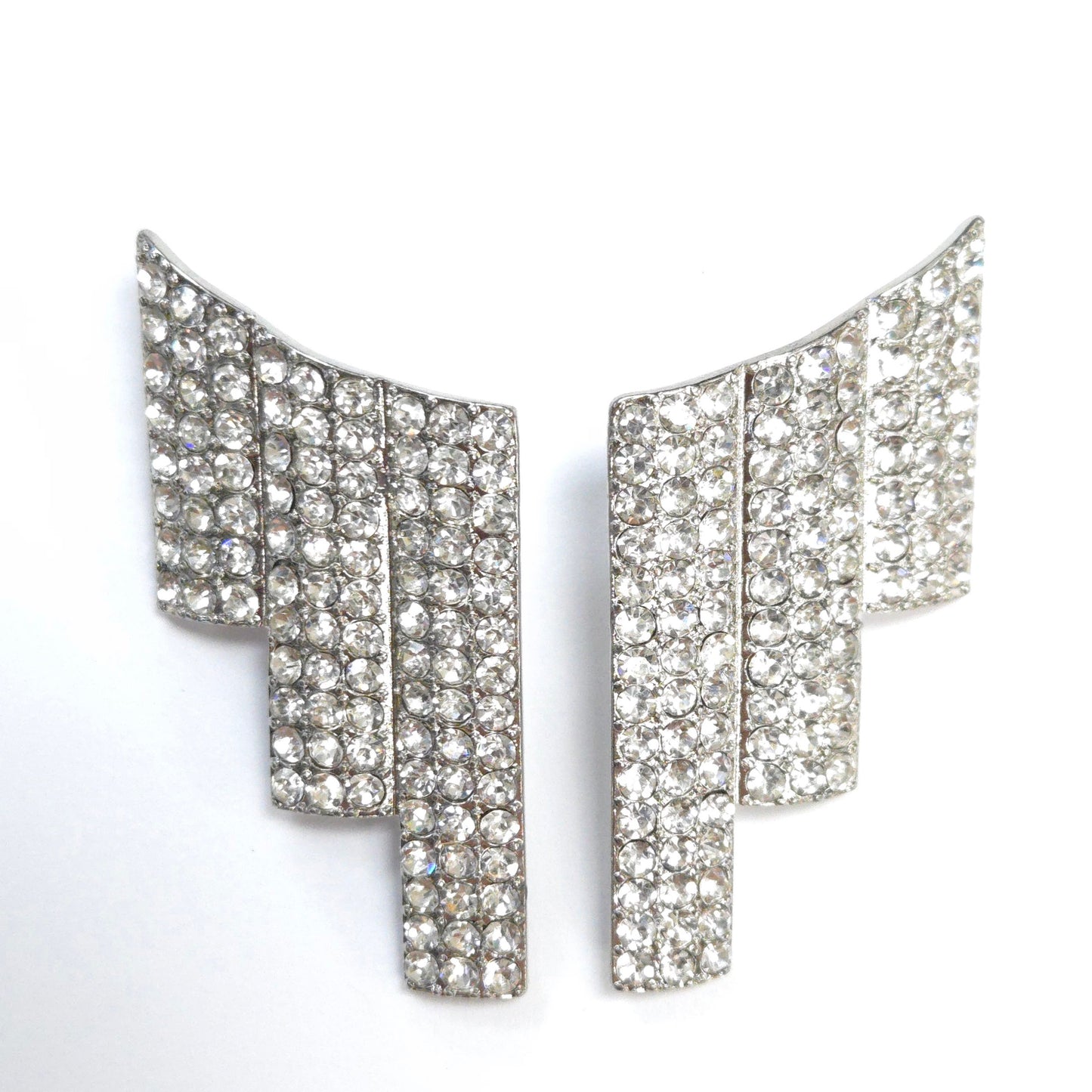 Pair of silver earrings with clear gemstones on a white background