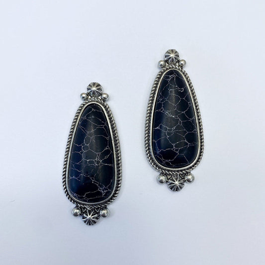 A pair of vintage style drop post earrings with a black stone design and metallic accents.