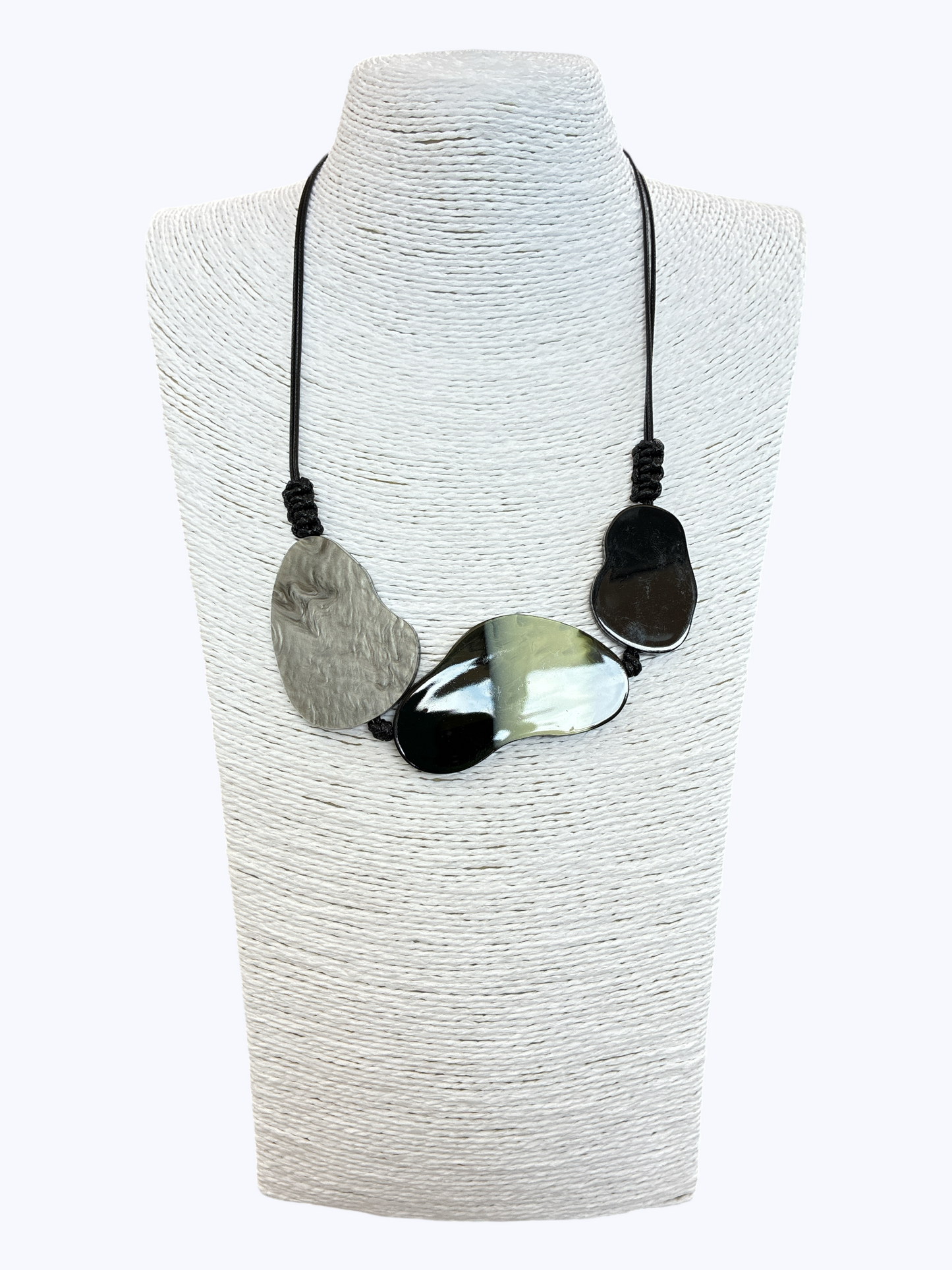 Abstract statement necklace with marbled black, gray, and white resin accents on black cord for a modern artistic boutique look.