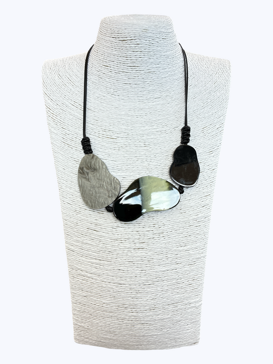 Abstract statement necklace with marbled black, gray, and white resin accents on black cord for a modern artistic boutique look.