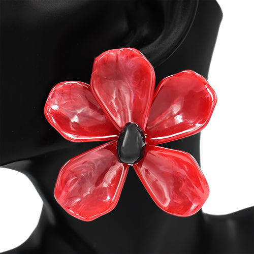 Red flower-shaped brooch with a black center on a black mannequin.