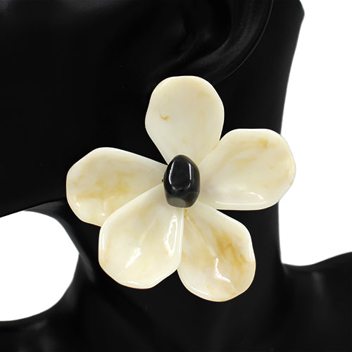 Floral-shaped brooch with a black center on a black background