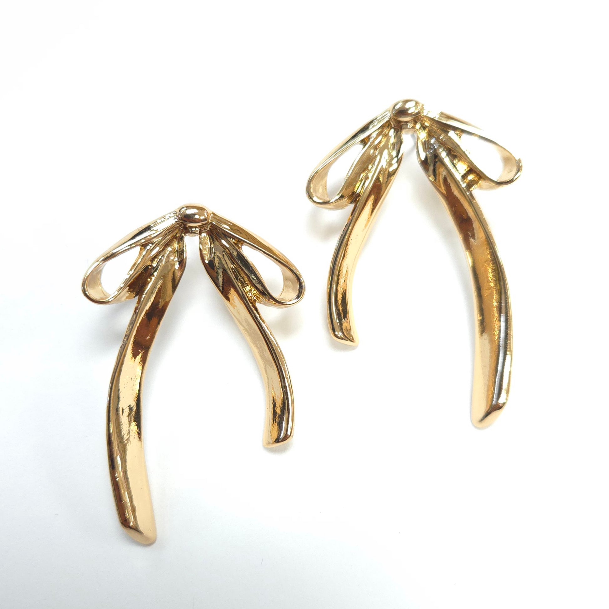 Gold leaf-shaped earrings on a white background
