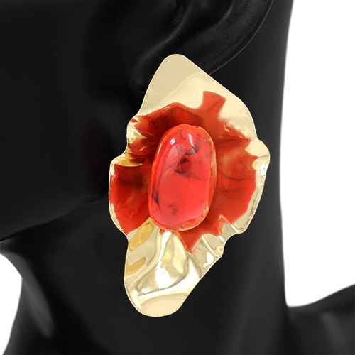 Gold and red stone brooch on a black background
