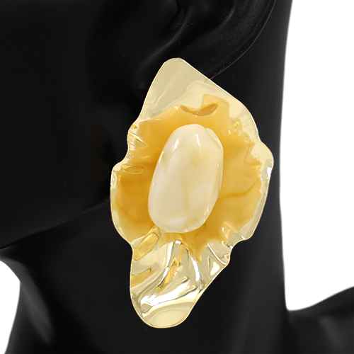 Gold brooch with a central pearl on a black background