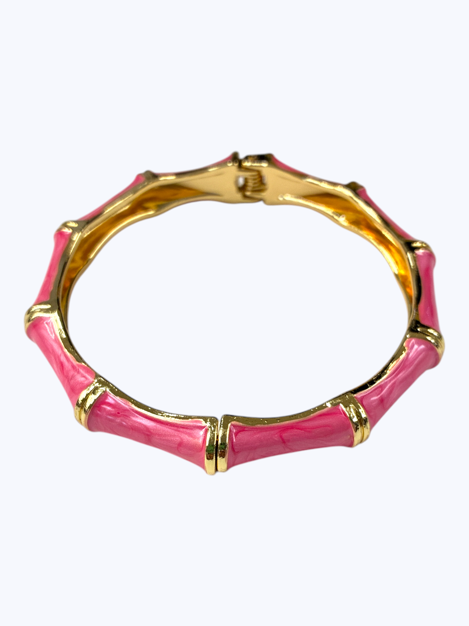 Pink bracelet with gold accents on a white background