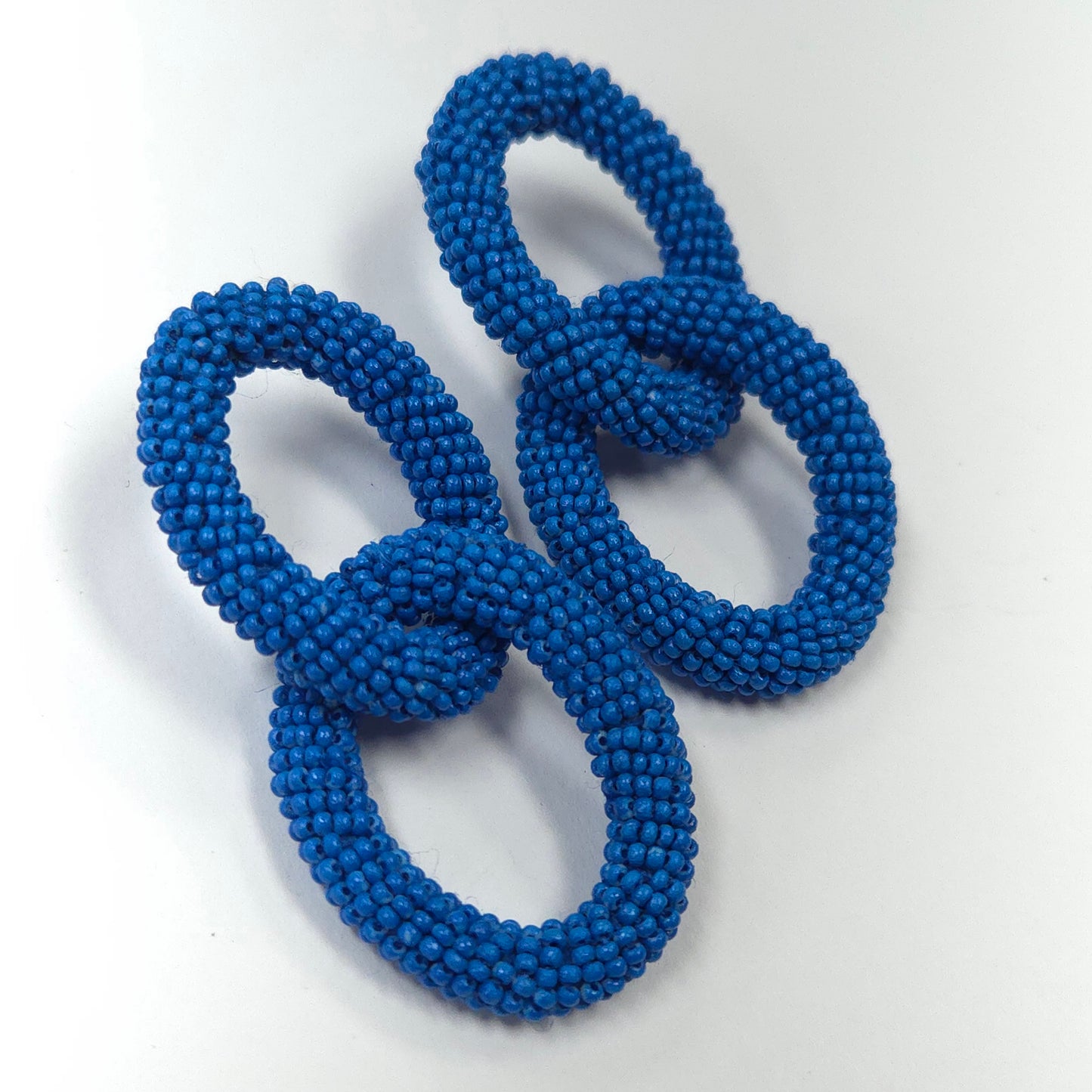 Two blue beaded loops on a white background