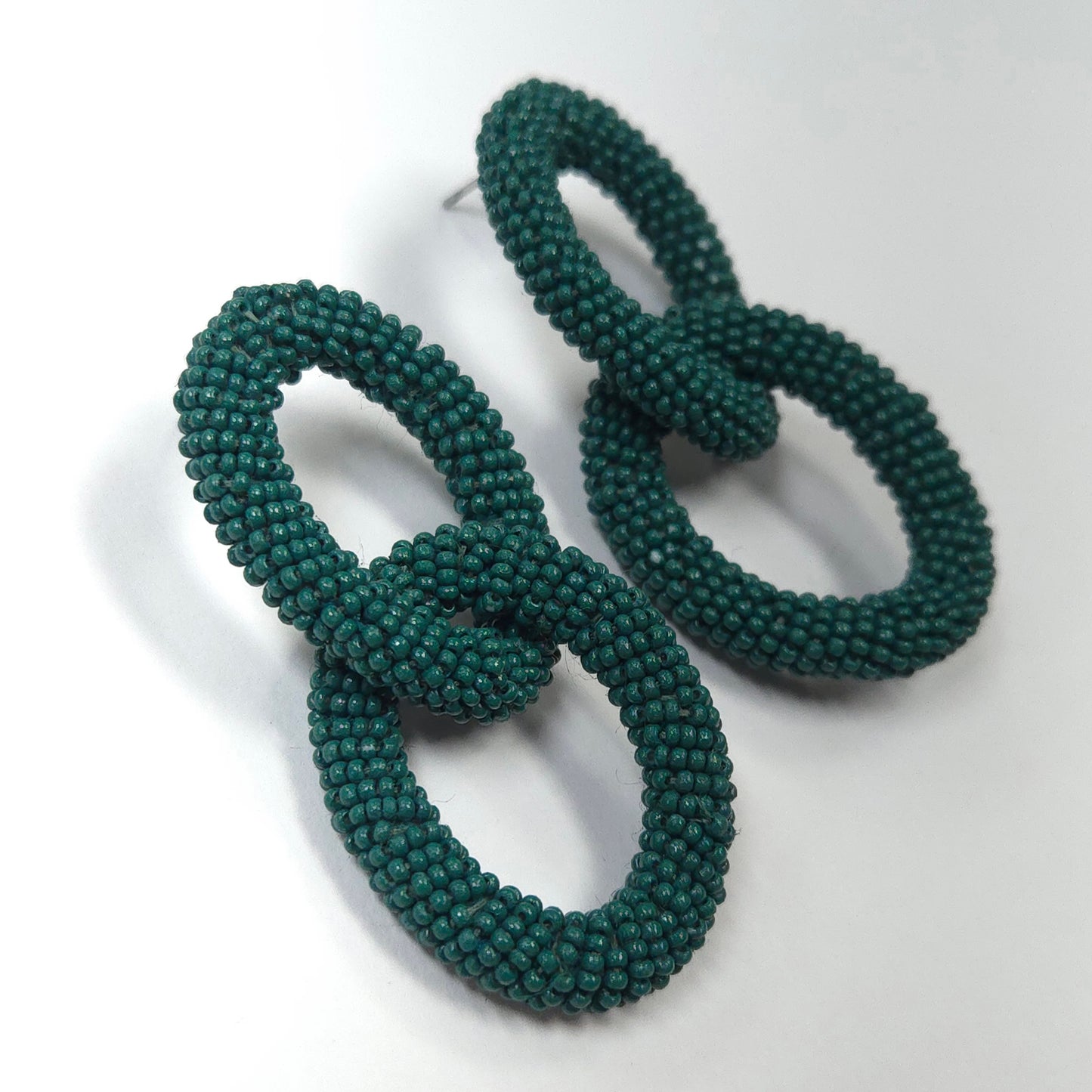 Pair of green beaded earrings on a white background