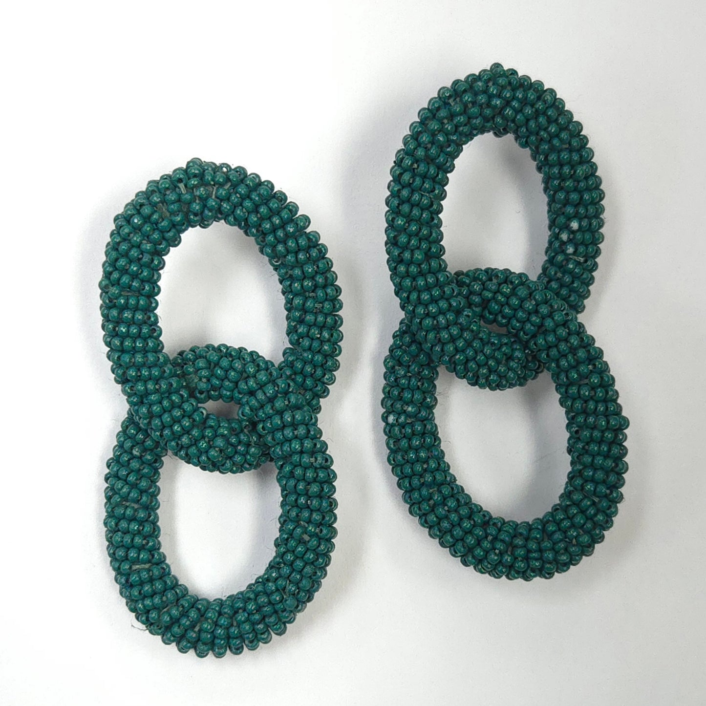 Pair of green beaded earrings on a white background