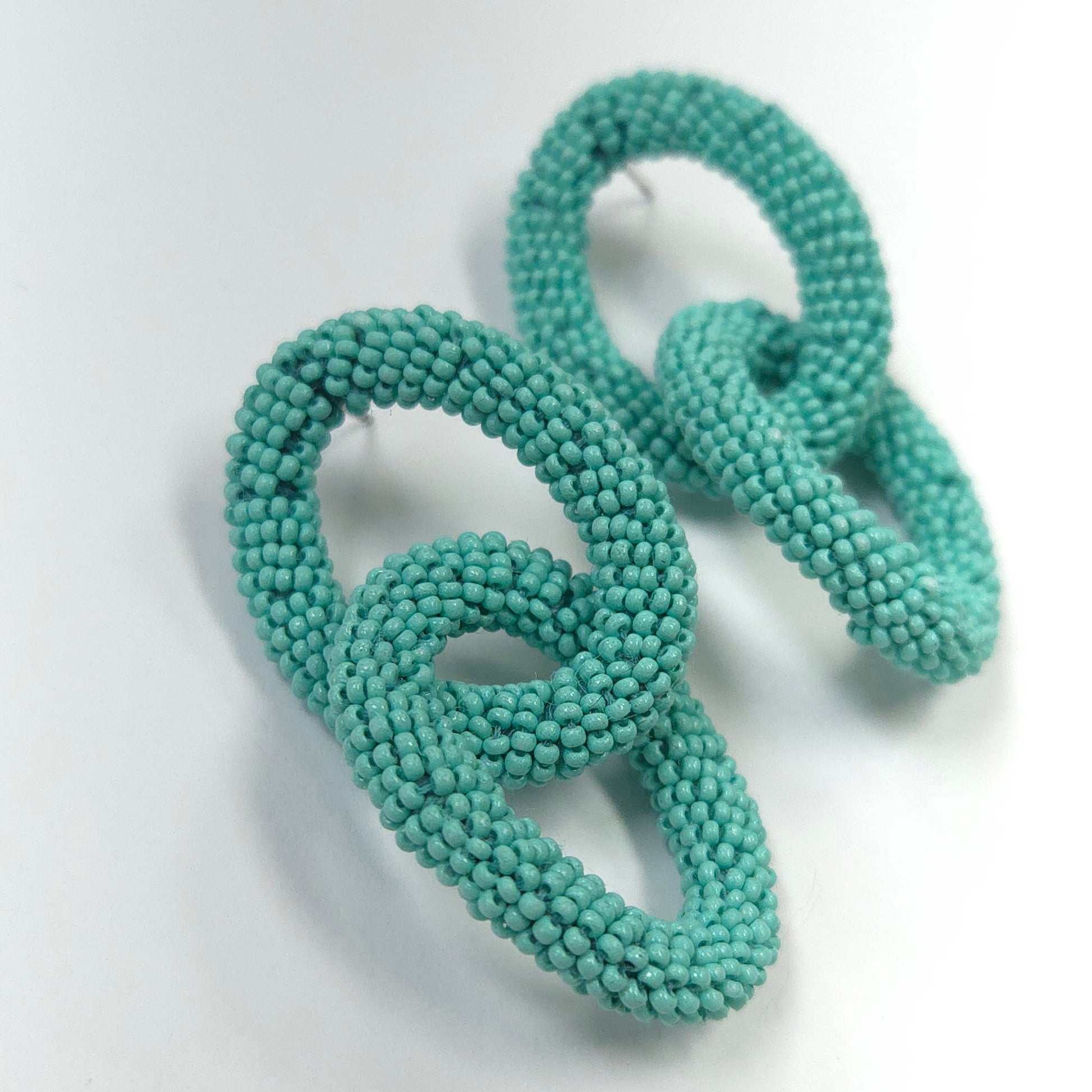 Turquoise beaded hair ties on a white background
