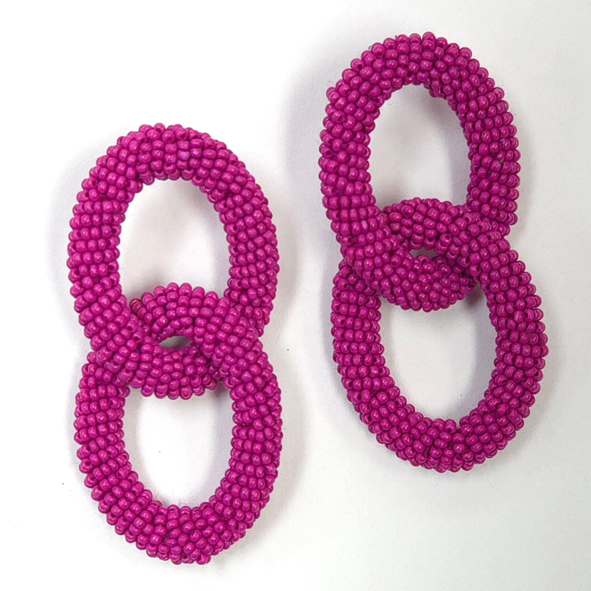 Pair of pink beaded earrings on a white background