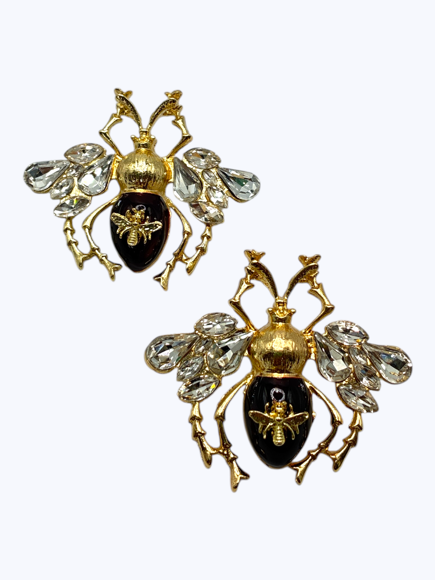 Gold bee statement earrings with crystal wing accents and glossy black enamel details for a bold glam boutique look.