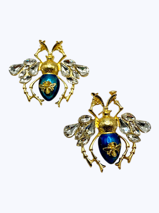 Gold bee statement earrings with crystal wing accents and deep blue enamel details for an elegant boutique-inspired statement look.