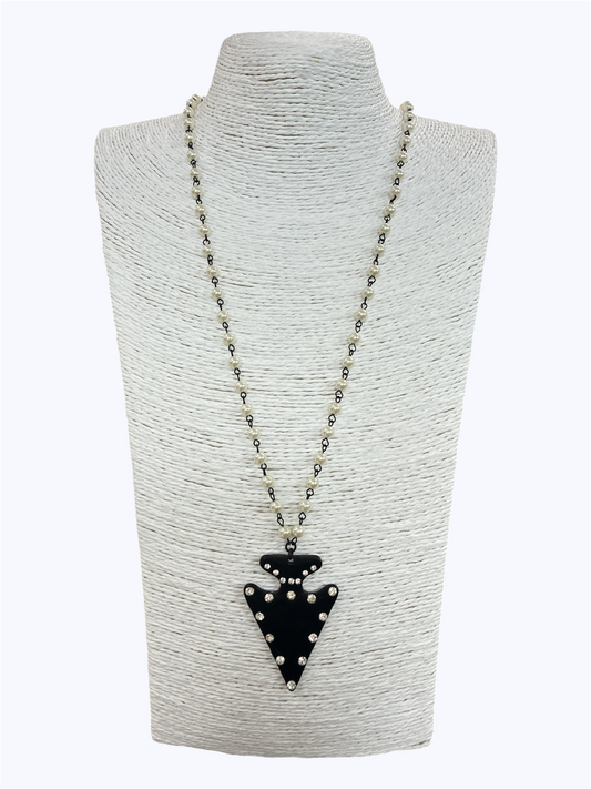 Long beaded necklace featuring a studded arrowhead pendant with western-inspired detailing and layered bead chain design.