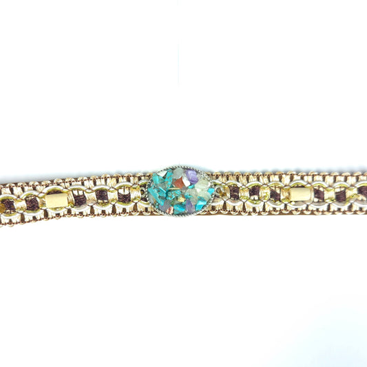 Bracelet with gold chain and multicolored gemstone on a white background