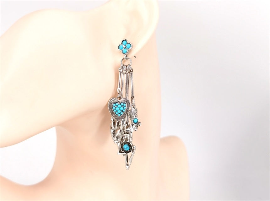 Earring with turquoise stones on a mannequin ear against a white background