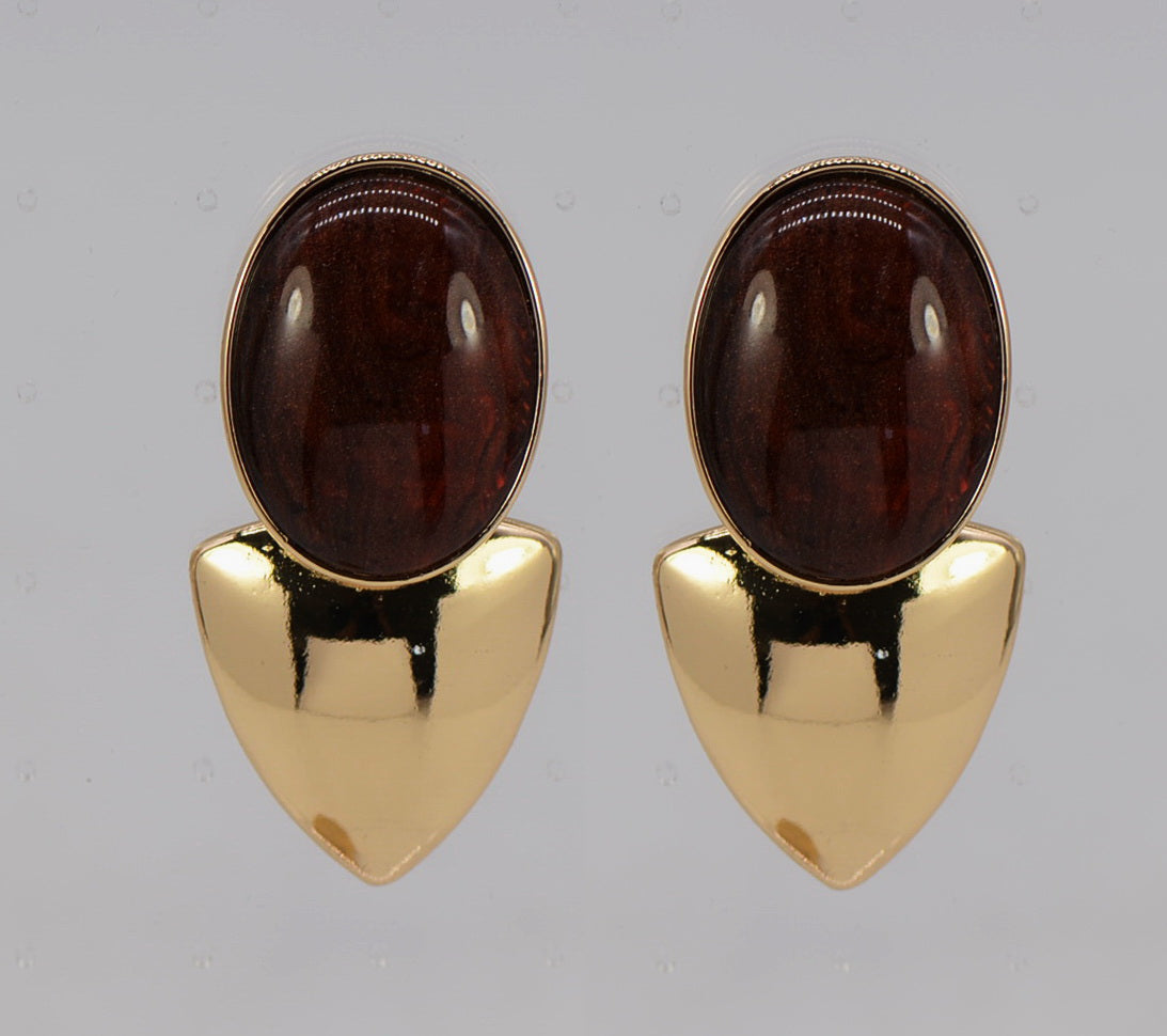 Pair of gold earrings with brown gemstones on a gray background