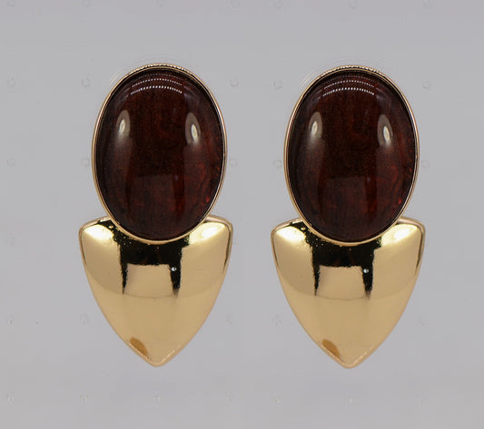 Pair of gold earrings with brown gemstones on a gray background