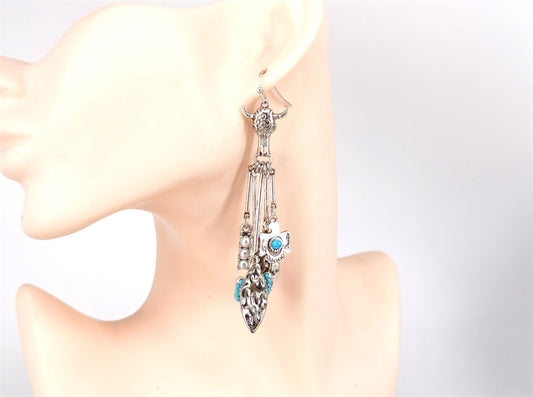 Earring on a mannequin ear with a white background
