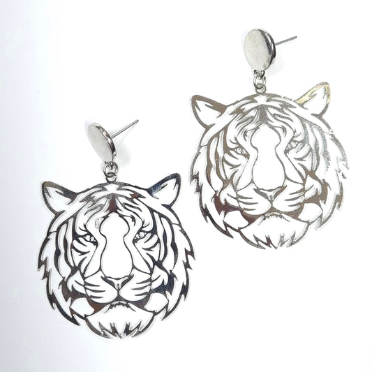 Silver tiger head earrings on a light gray background