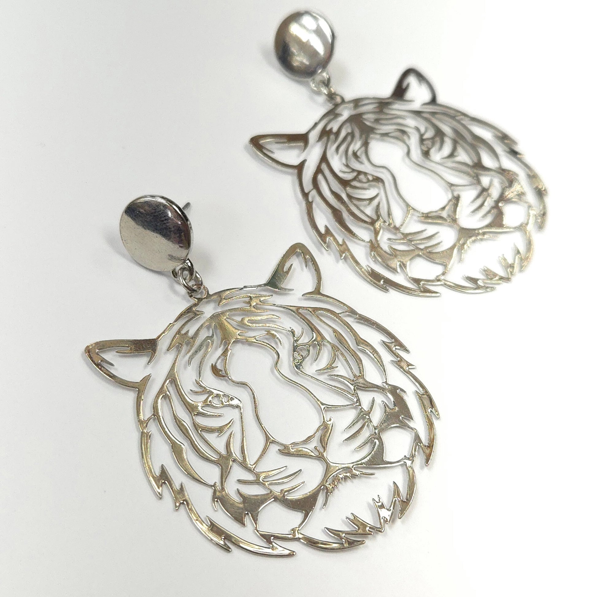 Silver earrings with intricate designs on a white background
