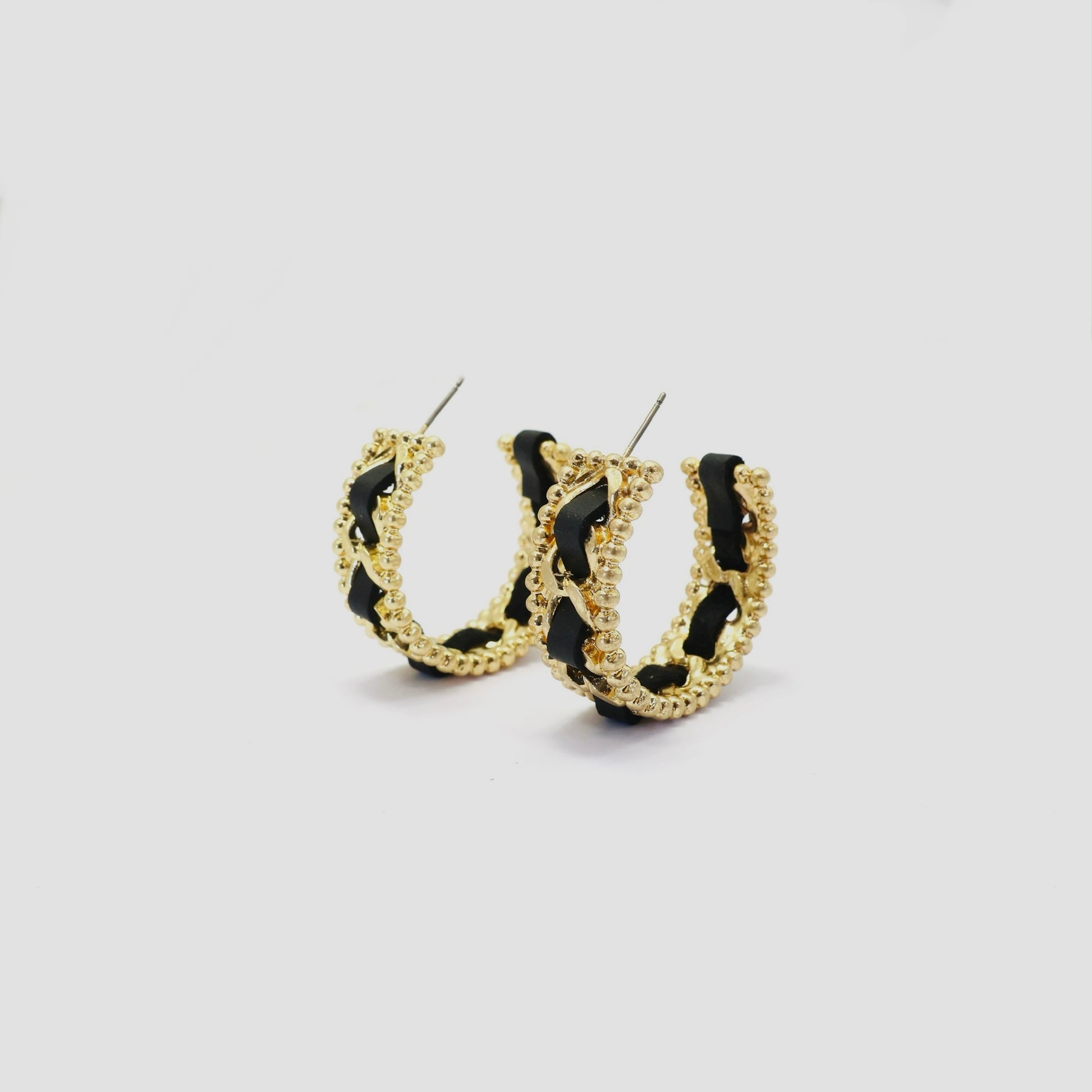 Braided chain hoop earrings with textured beaded edging and woven detail in a modern boutique fashion style.