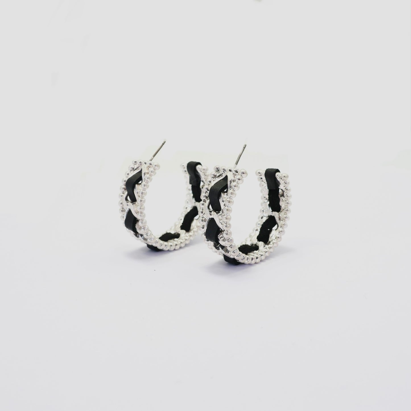 Braided chain hoop earrings with textured beaded edging and woven detail in a modern boutique fashion style.