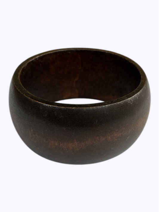Dark wood bangle bracelet with a smooth rounded silhouette and minimalist artisan style