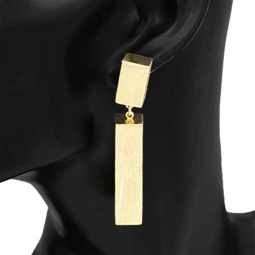 Gold bar earrings on a black ear with a black background