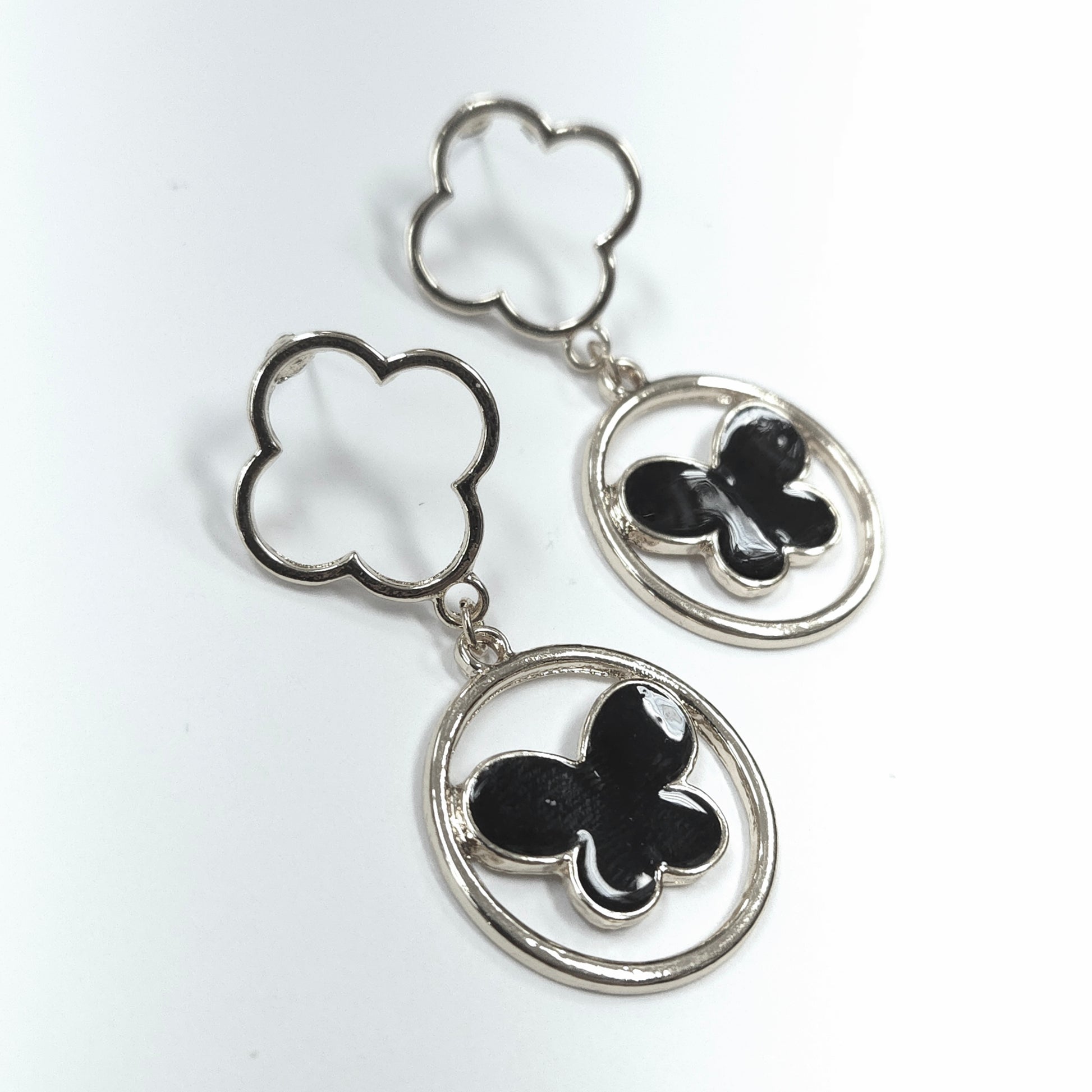 Butterfly-shaped earrings with silver and black design on a white background