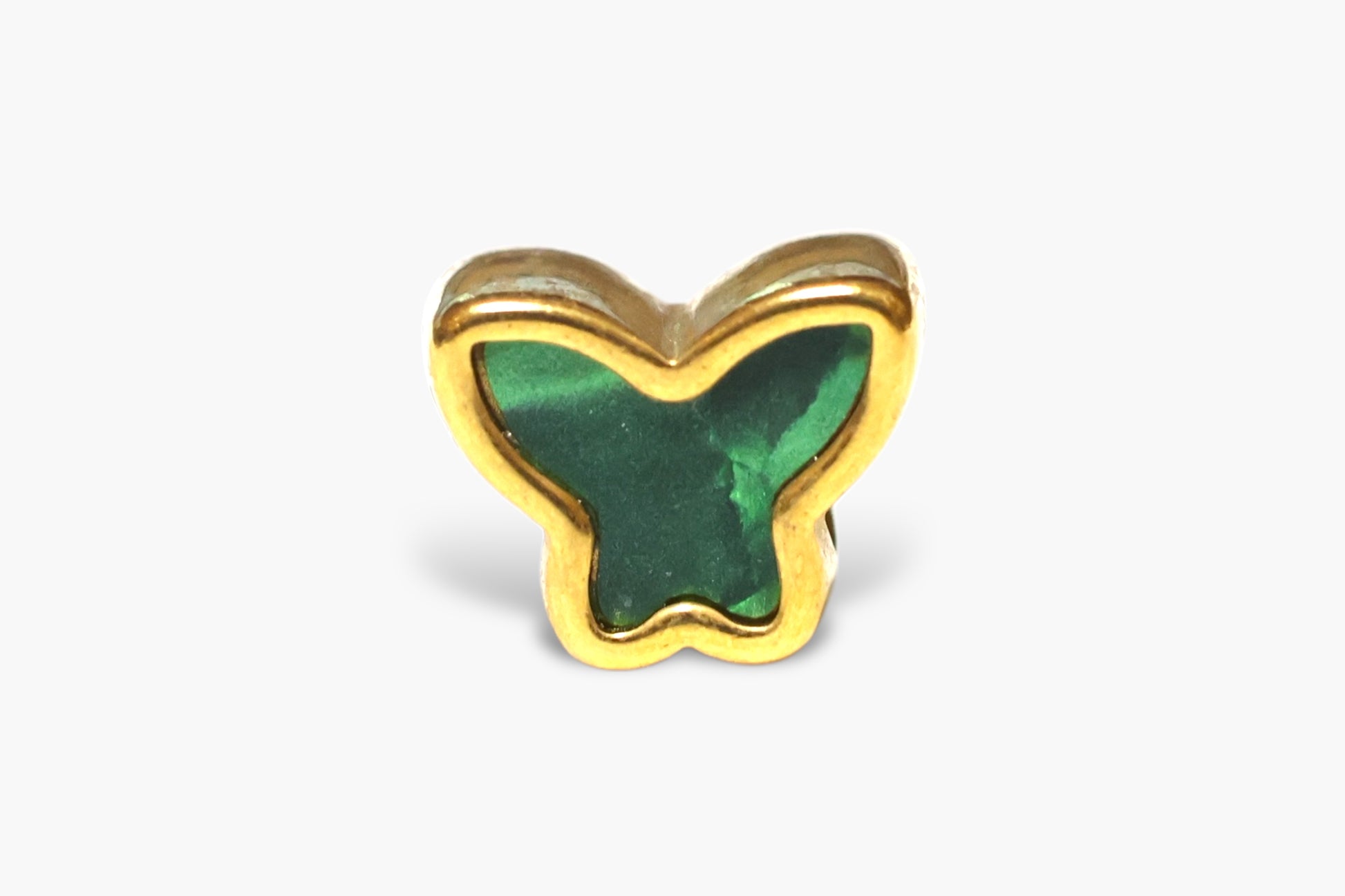 Butterfly-shaped object with green center and gold border on a white background