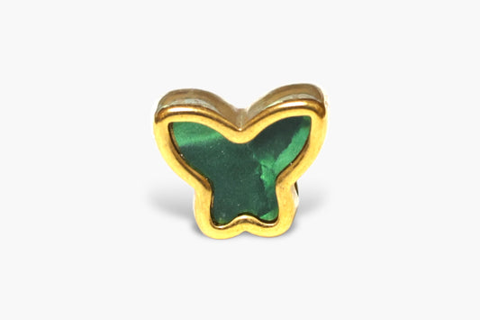 Butterfly-shaped object with green center and gold border on a white background