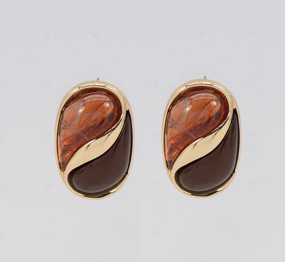 Pair of gold and amber teardrop earrings on a light gray background