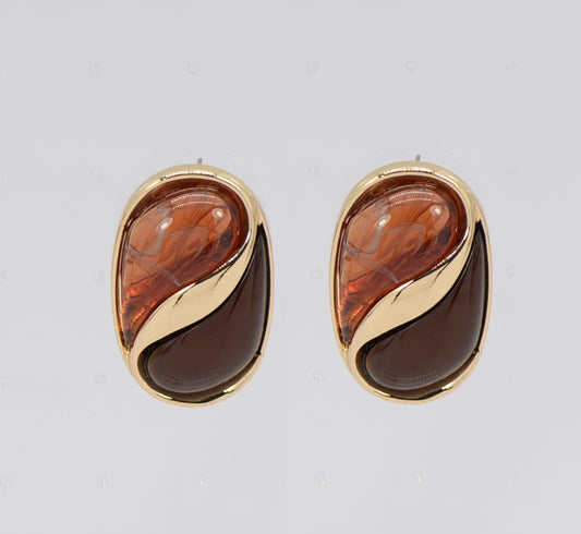 Pair of gold and amber teardrop earrings on a light gray background