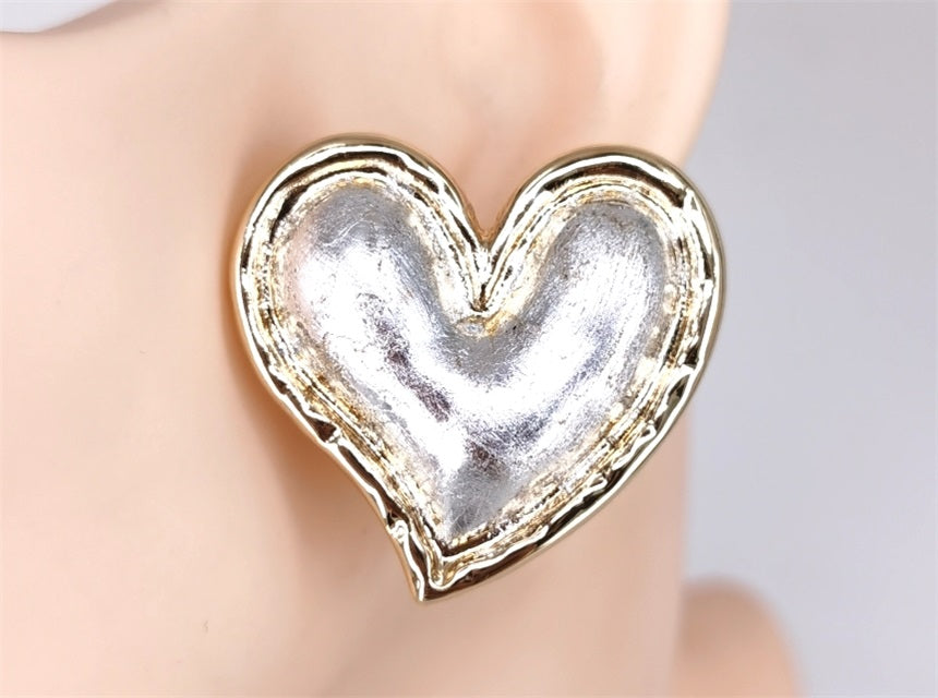 Heart-shaped silver earring on a mannequin