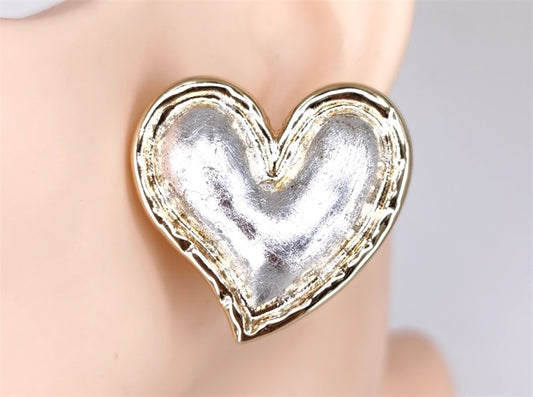 Heart-shaped silver earring on a mannequin
