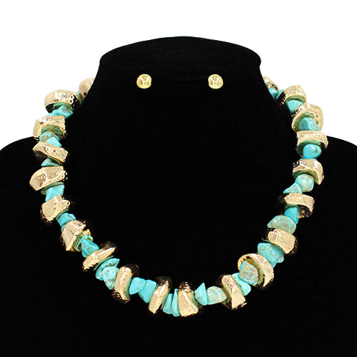Turquoise and gold necklace on a black stand