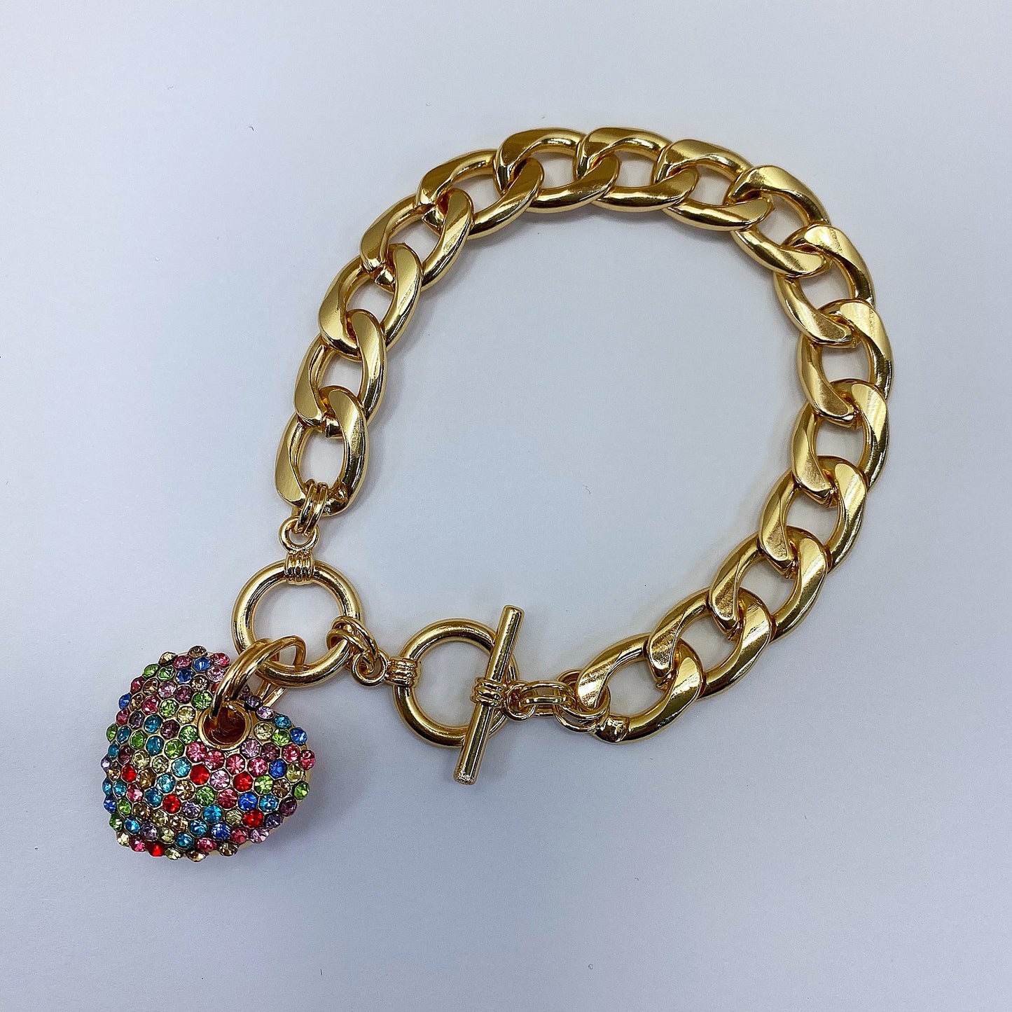 Gold chain bracelet with a heart-shaped charm featuring colorful beads on a white background