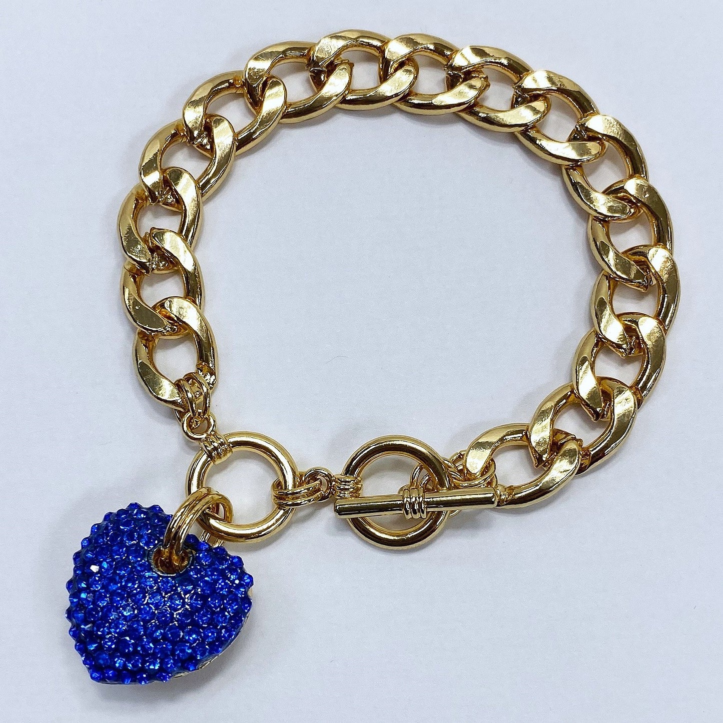 Gold chain bracelet with a blue heart-shaped charm on a white background
