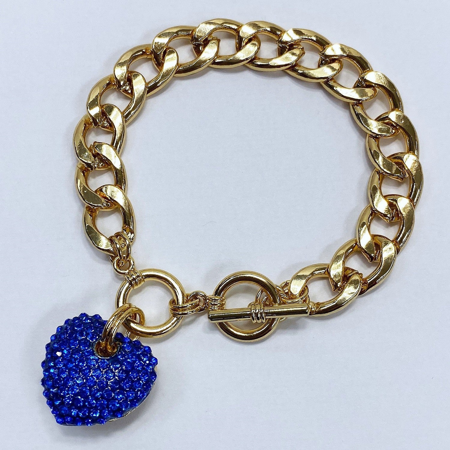 Gold chain bracelet with a blue heart-shaped charm on a white background
