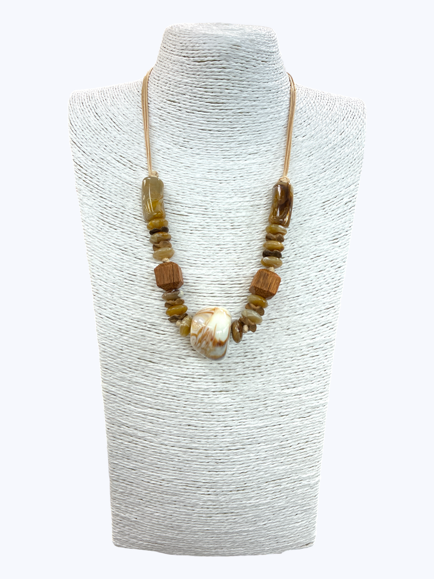 Natural stone and wooden bead statement necklace with large marbled shell pendant and earthy neutral tones on braided cord display.