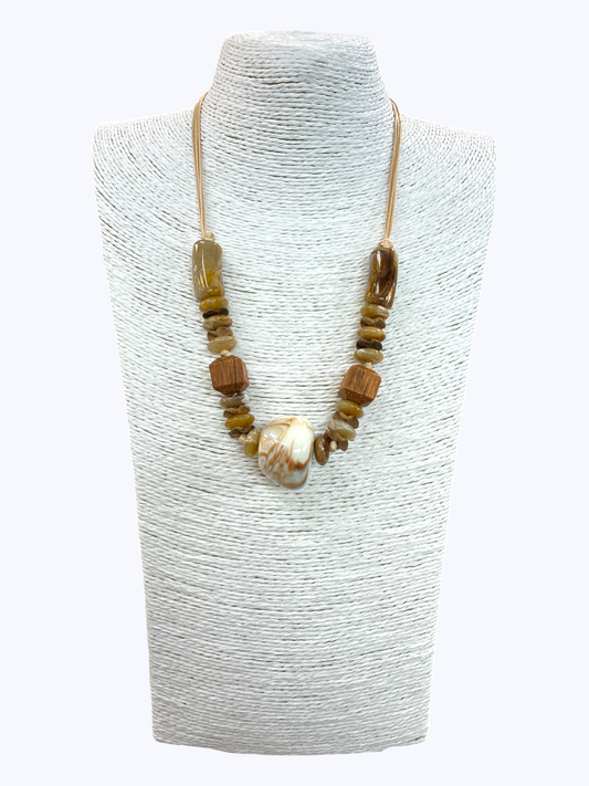 Natural stone and wooden bead statement necklace with large marbled shell pendant and earthy neutral tones on braided cord display.