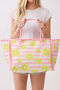 Person holding a pink and green striped bag with lemon designs on a plain background